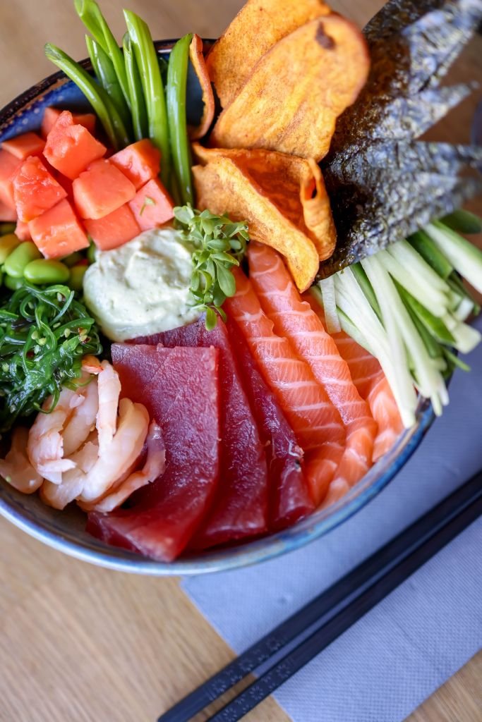 Colorful poke bowl featuring fresh salmon, tuna, and vegetables, perfect for Asian cuisine lovers.